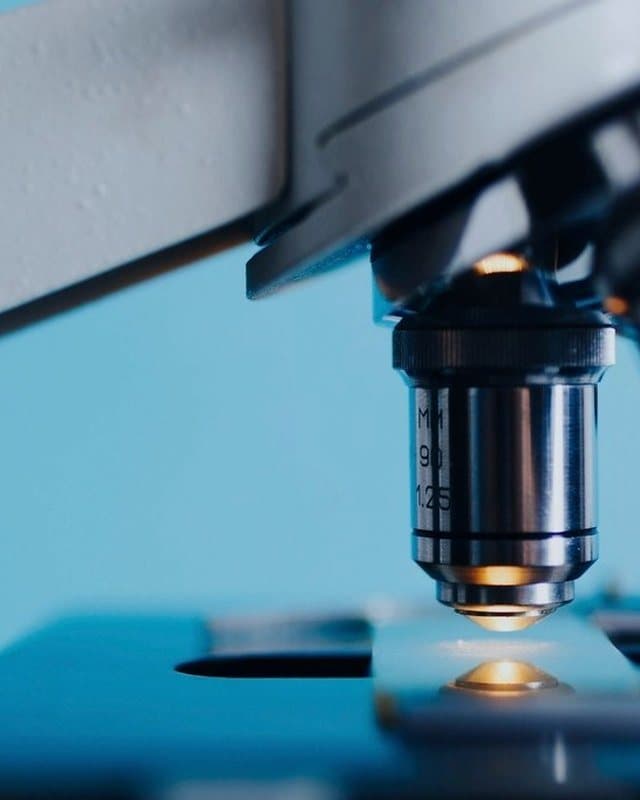 Detalhe de microscópio de laboratório em tons de azul